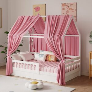 Ciel de lit en mousseline rose drapé sur un lit cabane blanc dans une chambre d'enfant