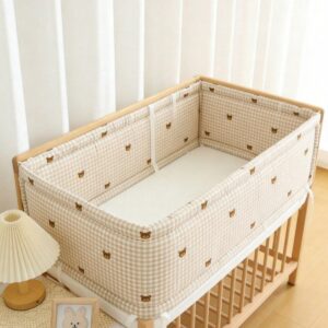 Tour de lit vichy beige à oursons brodés posé sur un lit à barreaux en bois