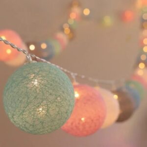Boules de coton pastel allumées d'une guirlande lumineuse, vert d'eau et rose