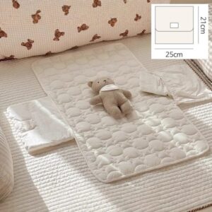 Matelas matelassé crème déployé sur un lit, avec sa cote de pliage