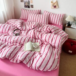 Parure de lit rayée rose avec ses deux taies, sur un lit d'enfant